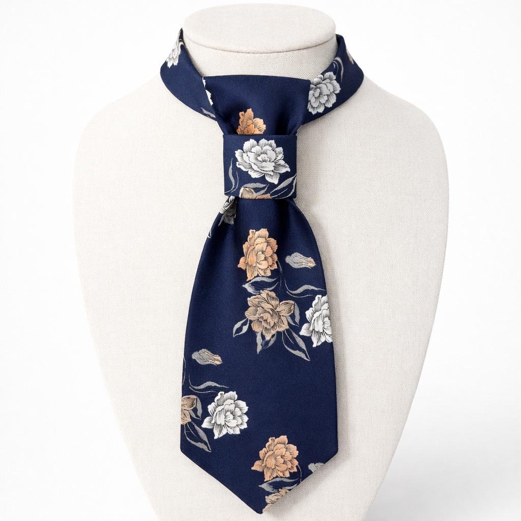 A repurposed 1970s navy floral polyester tie reworked into a women's continental crossover tie with an adjustable gold chain.