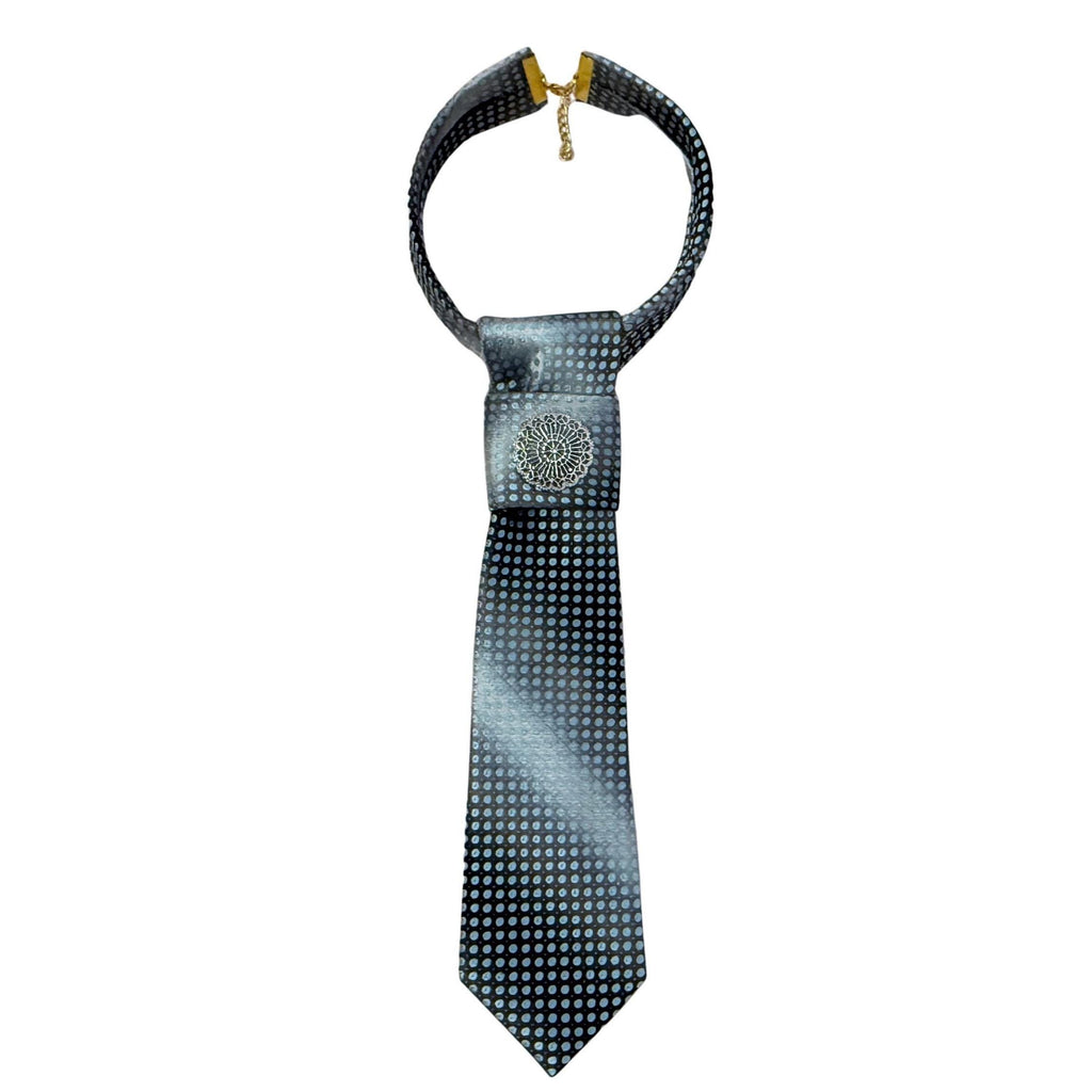 A hand-styled women's necktie displayed on a cream bust, showcasing the transition from dark charcoal edges to a light silver centre.
