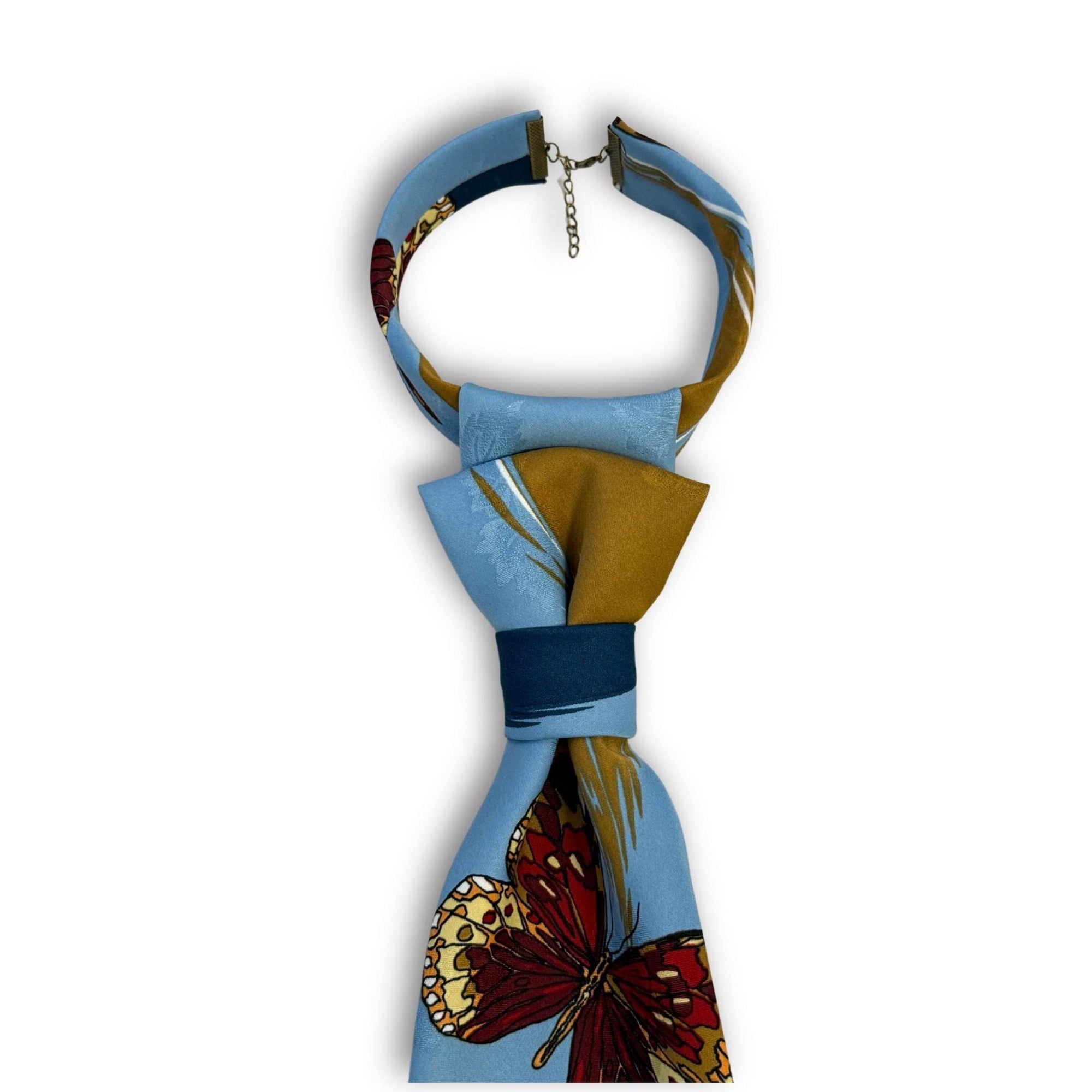 A hand-styled women's necktie in bright blue and gold, displayed on a clean white background to highlight the tiered fold and nature-inspired print.
