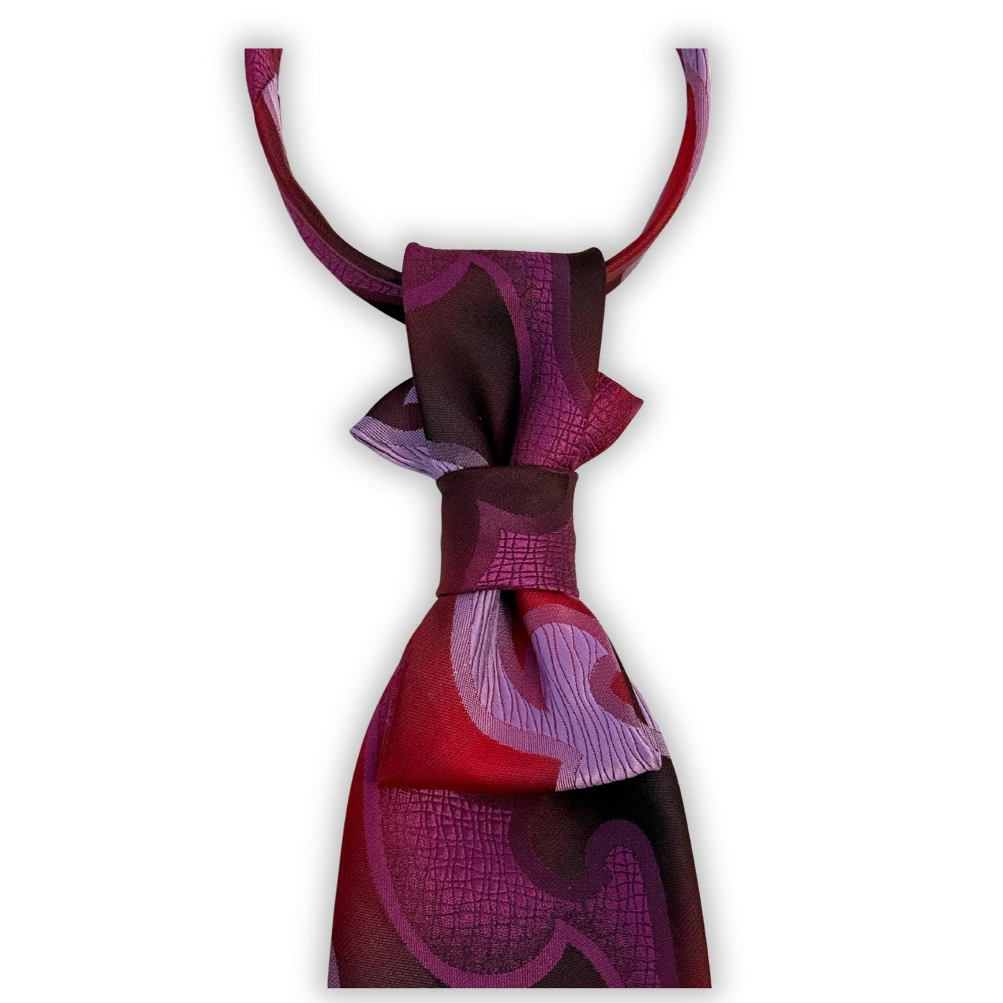 Close-up of the vibrant abstract graphic on a reworked Lancer tie, highlighting the durable, washable fabric and the gold-tone clasp.