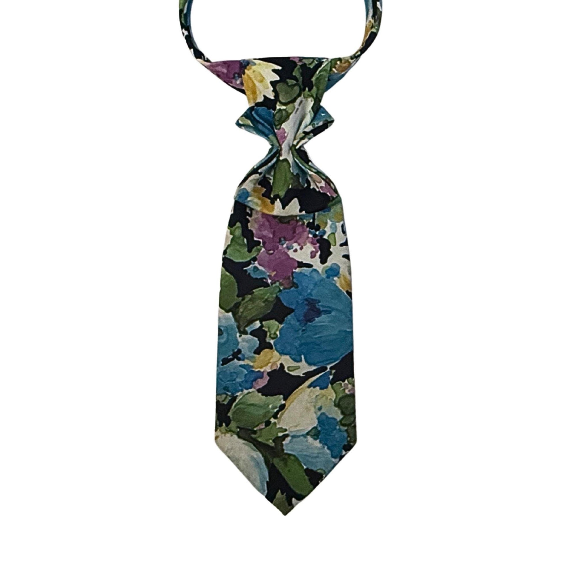 A repurposed blue-toned floral vintage tie reworked into a women's continental crossover style with a dark adjustable chain.