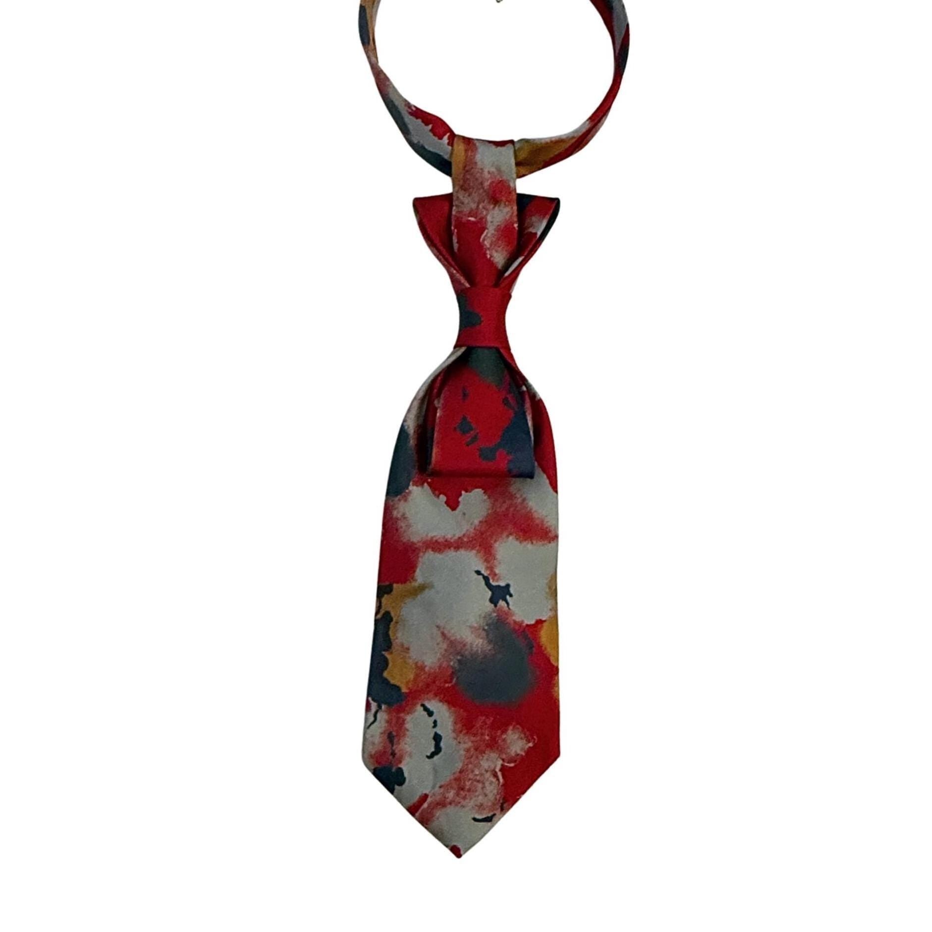 A hand-styled women's necktie in vivid red and smoky grey, displayed on a neutral background to highlight the architectural fold and one-of-a-kind print.
