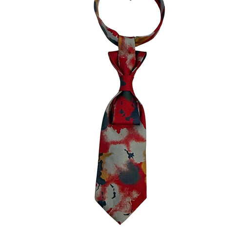 A hand-styled women's necktie in vivid red and smoky grey, displayed on a neutral background to highlight the architectural fold and one-of-a-kind print.