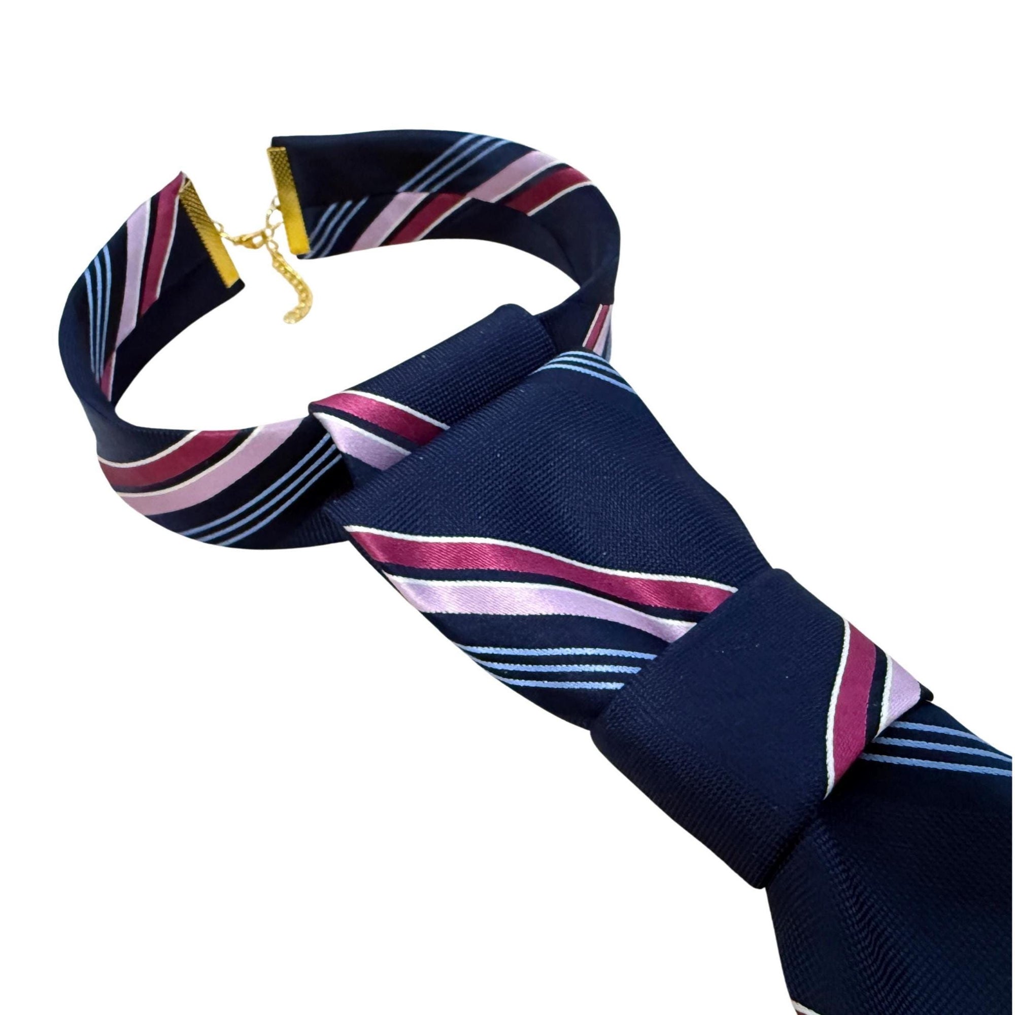 Detailed shot of the adjustable gold clasp on a navy striped Michael Kors tie, showing the subtle MK logo visible on the inner silk tipping.