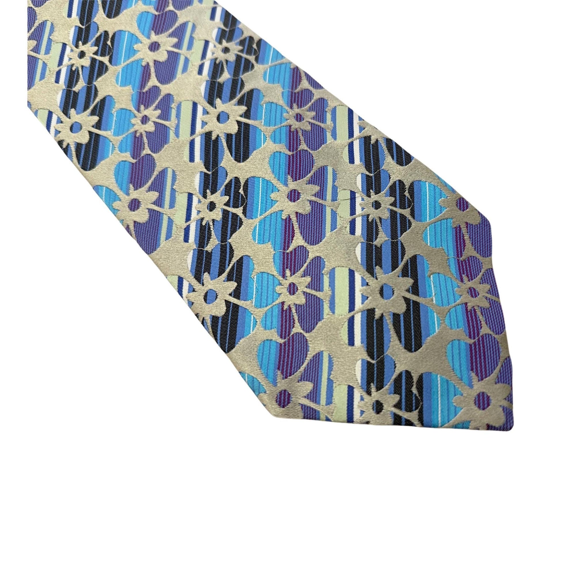 Close-up of an Etro Milano silk tie with blue stripes and violet floral patterns on a champagne gold background.
