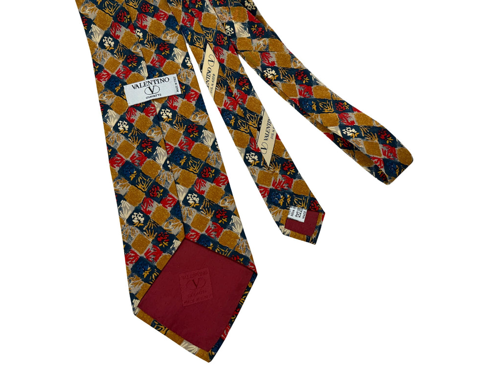 Authentic vintage Valentino Garavani silk tie. Features a 10cm blade in a rare ochre and crimson geo-floral print. Hand-finished in Italy for the modern, self-assured professional.