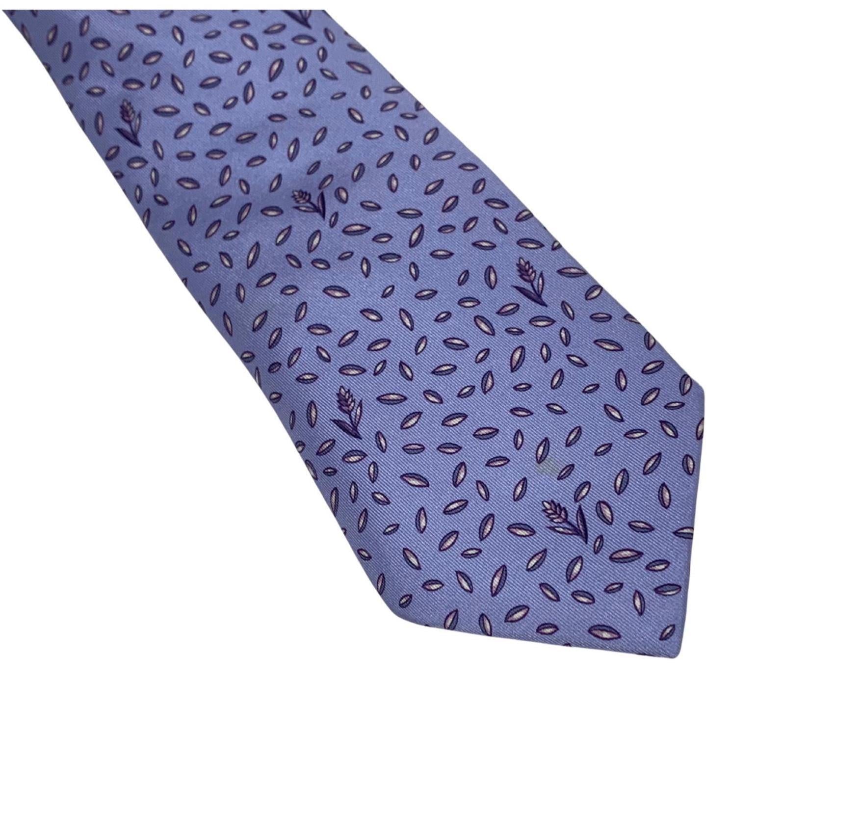This Hermès silk tie is a sophisticated blend of whimsical motif and classical elegance. Featuring a meticulous "Wheat & Seed" pattern in shades of deep lavender, violet, and soft periwinkle, this piece captures the refined, pastoral aesthetic that has made Hermès a pillar of luxury neckwear.