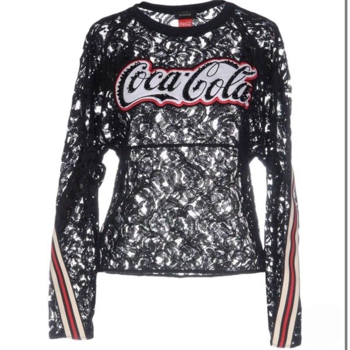 This top is a result of the exciting collaboration between Coca Cola and Pinko, showcasing the perfect synergy of fashion and pop culture. Authentic Coca-Cola for Pinko collaboration top. Featuring Italian black lace, sequined logo, and athletic striped cuffs. Very good condition. Made in Italy.